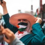 a person with a brown hat wearing palestine flag mask