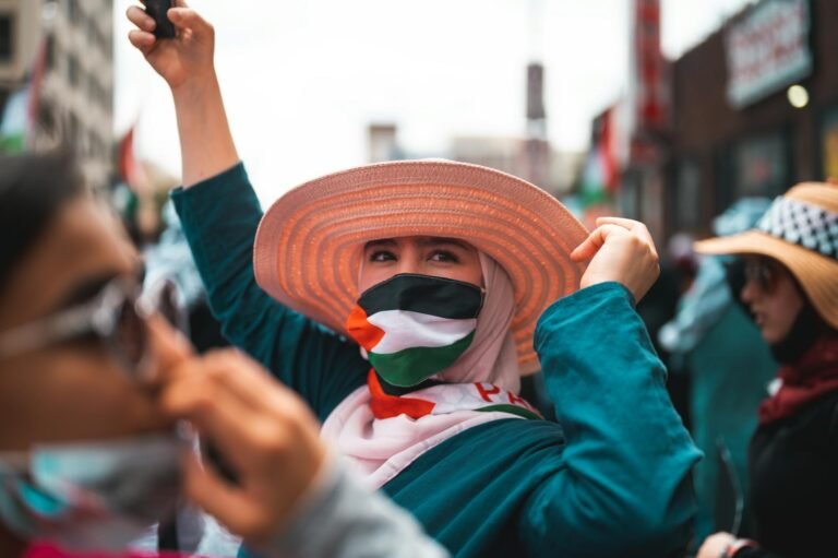 a person with a brown hat wearing palestine flag mask