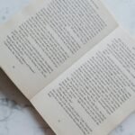 opened book lying on marble desktop