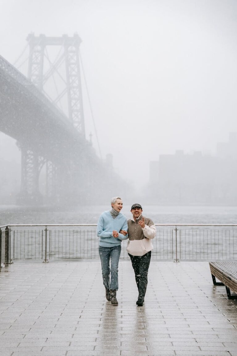 content couple talking on urban embankment against river in mist