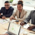 photo of three people smiling while having a meeting