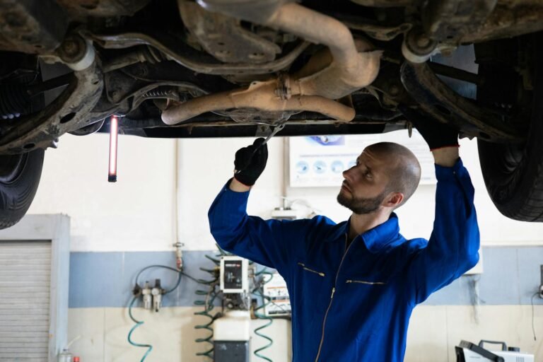 man in blue coverall fixing a vehicle